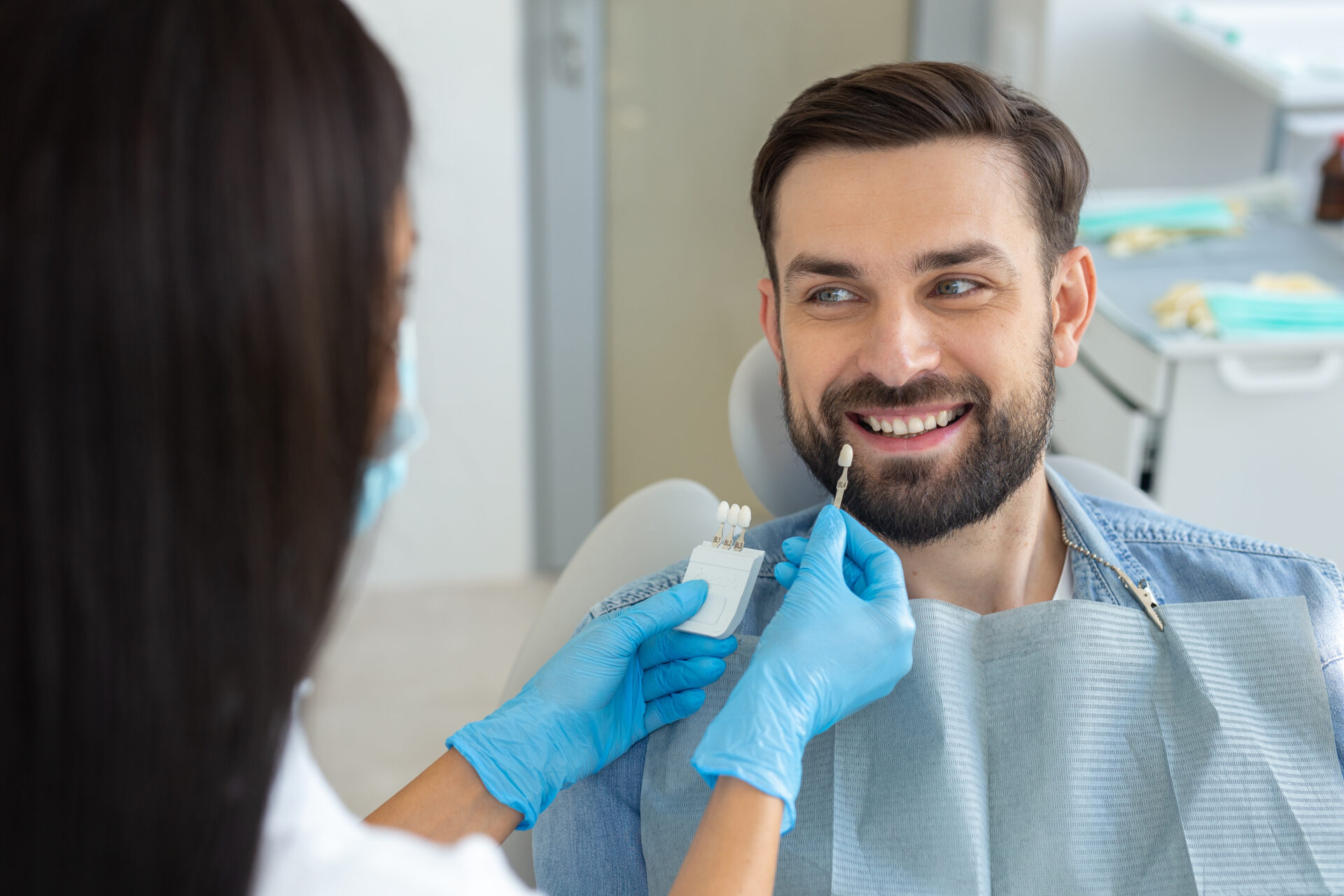 Female doctor and patient choosing tooth implants in modern dental clinic