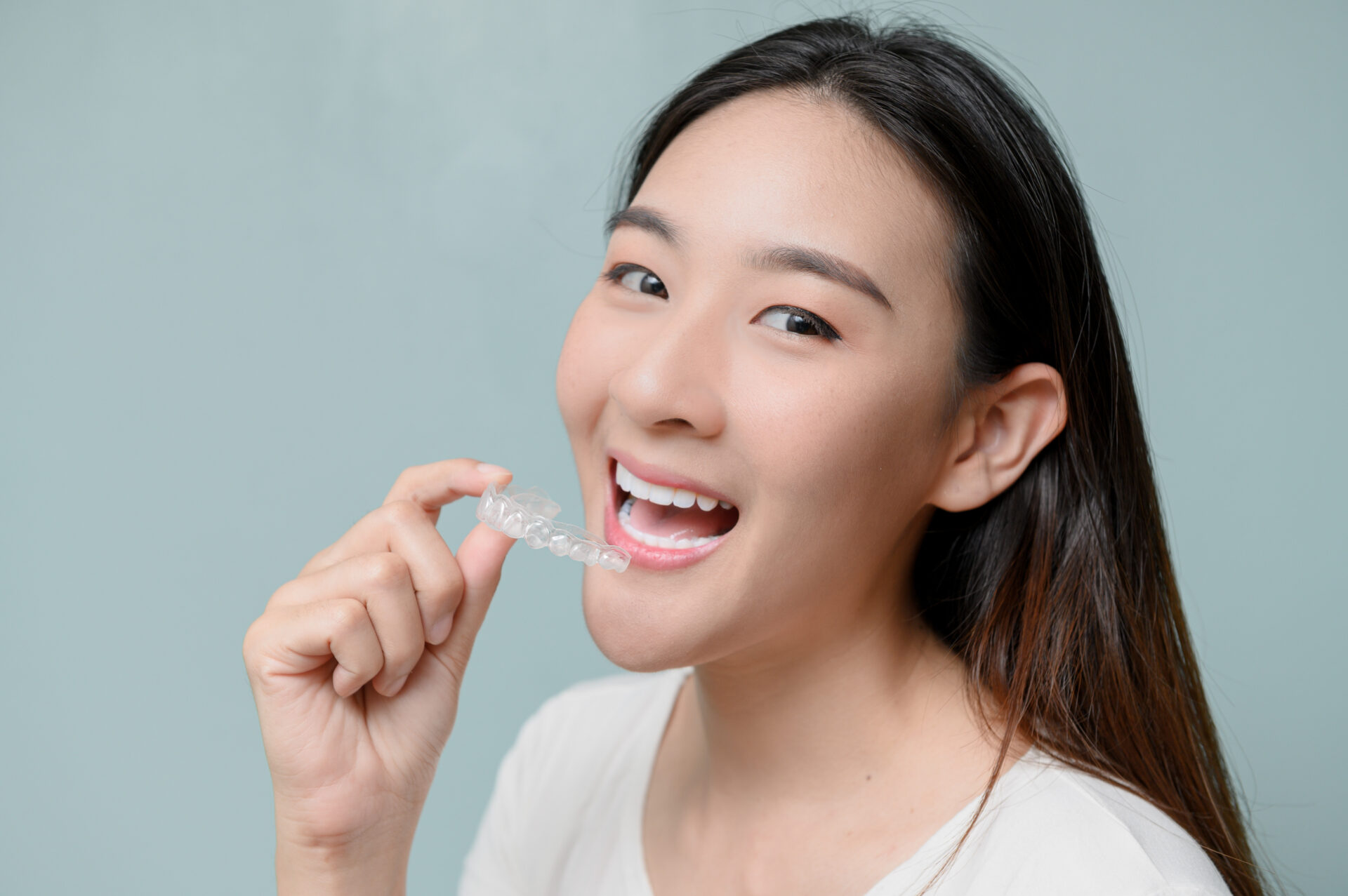 Woman wearing orthodontic silicone trainer. Mobile orthodontic appliance for dental correction. tooth whitening systems.